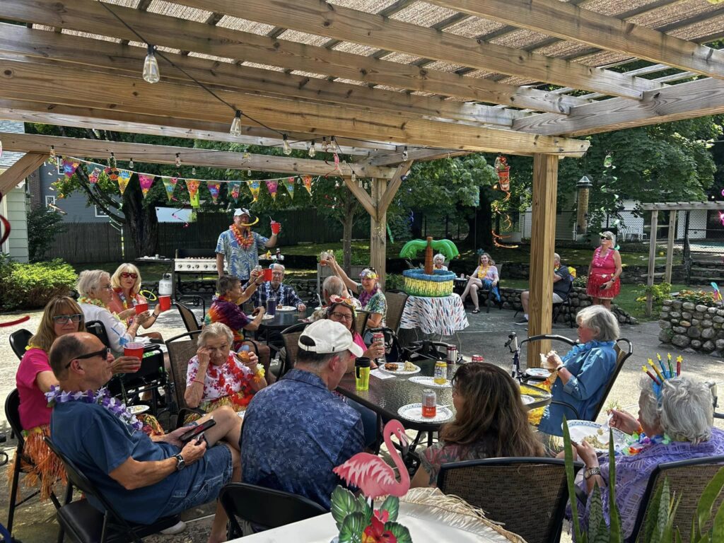 Residential assisted living residents participating in a luau outside of the home.