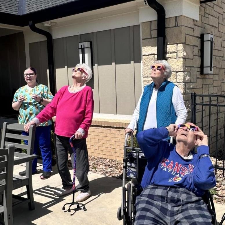 Residential assisted living residents enjoying the solar eclipse on the patio.