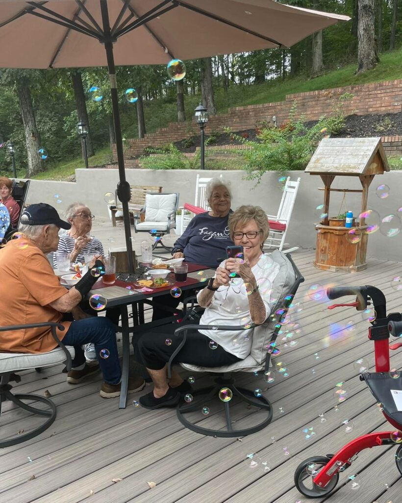 Residential assisted living community enjoying the outside porch with bubbles.