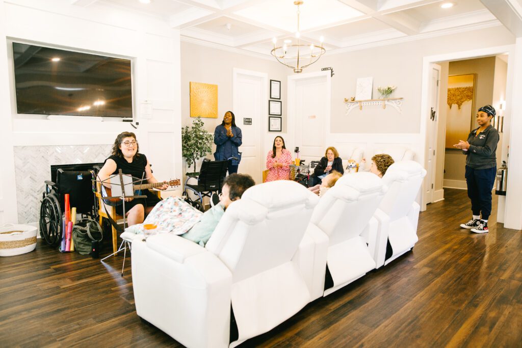 Residential assisted living room with residents listening to music.